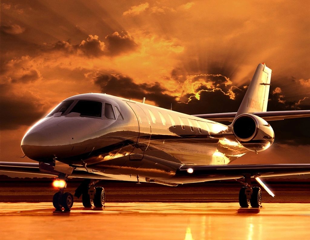 Photo of business aircraft on ground with clouds in background.