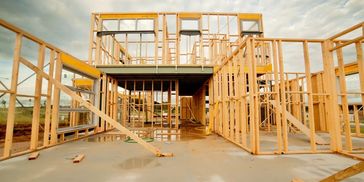 Wooden framework of a house under construction on a concrete foundation.