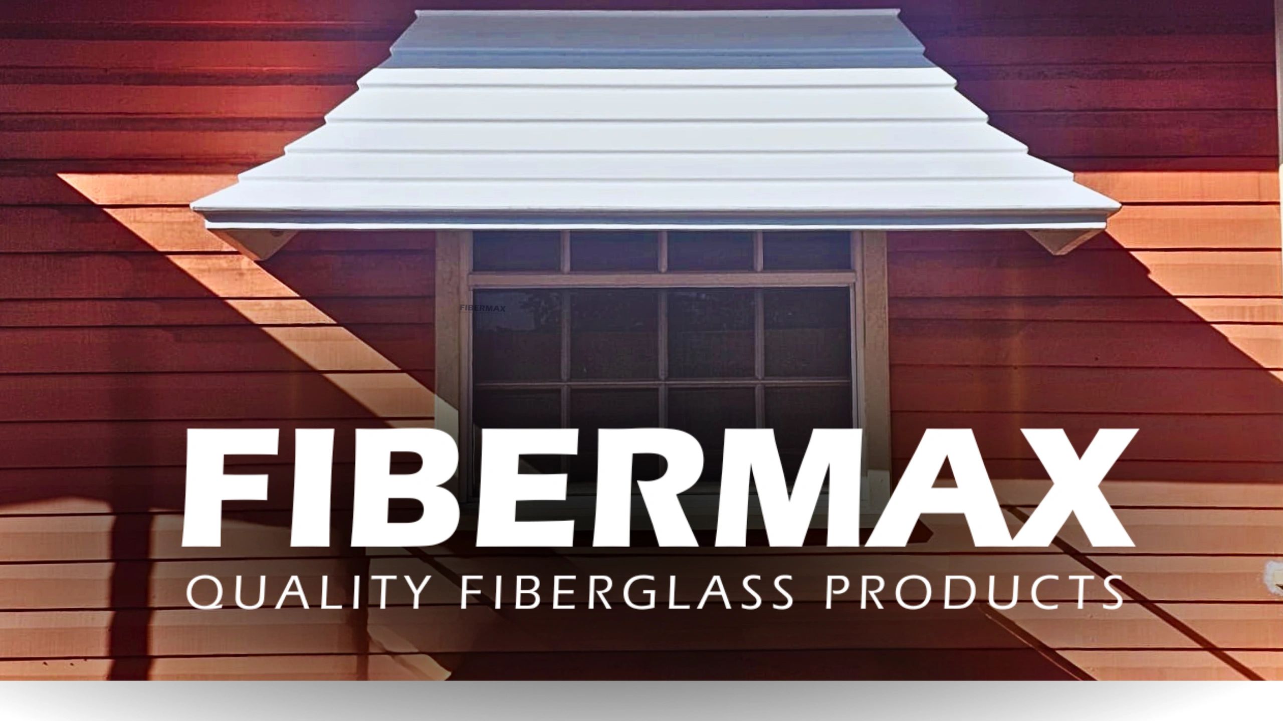 White fiberglass Bell-Shaped window hood over a window on a red wooden house with FIBERMAX branding.