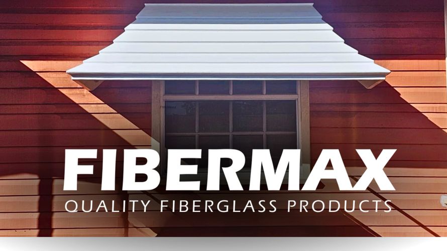White fiberglass Bell-Shaped window hood over a window on a red wooden house with FIBERMAX branding.