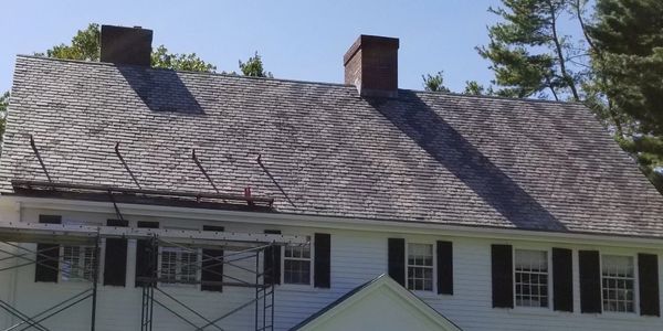 A house with scaffolding around the roof of it.