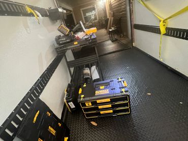 Organized DeWalt toolboxes and storage in a clean trailer interior.