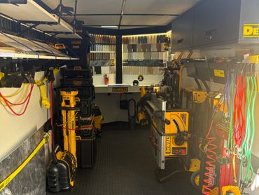 Organized tool storage inside a mobile workshop van with DeWalt equipment.