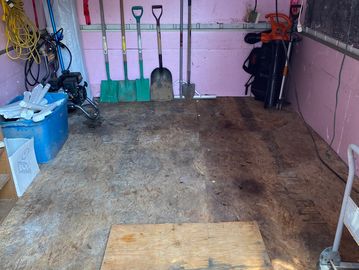 Photo of clients shed after clean-up. The garage is almost empty with a few shovels/gardening tools.