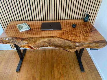 Handcrafted live edge wooden desk with black metal legs and minimalist decor.