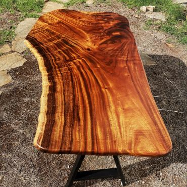 Polished wooden table with rich grain patterns outdoors.