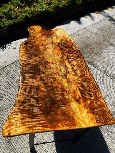 A polished wooden table with a rich, golden-brown grain pattern.