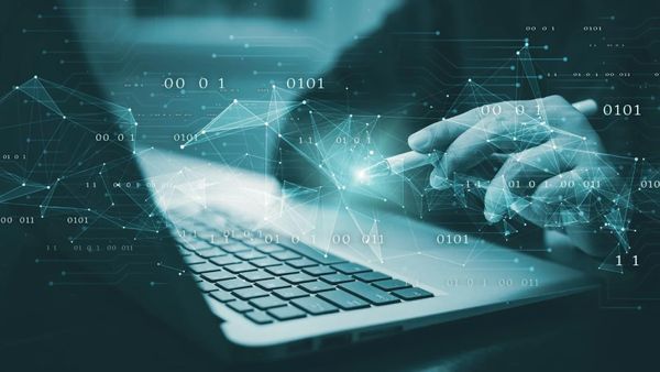 Hand interacting with a laptop surrounded by digital binary code and network connections.