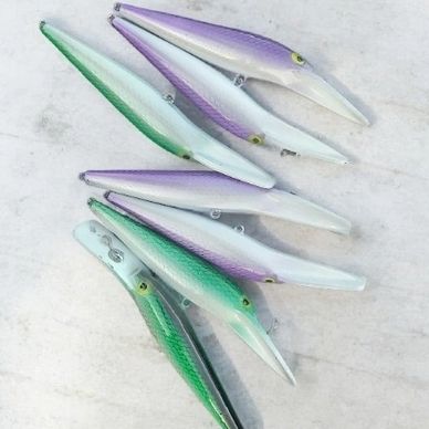 A set of colorful fishing lures arranged on a light surface.