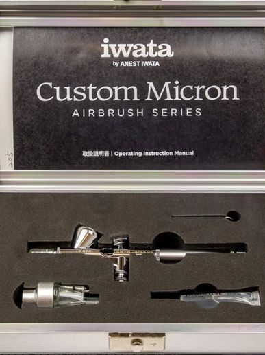 Iwata Custom Micron airbrush kit with instruction manual in a metal case.