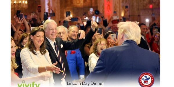 People greeting a man at the Lincoln Day Dinner event.
