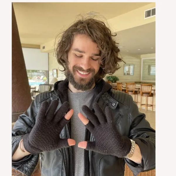 A man showing his black colored two finger gloves