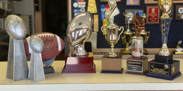 A collection of football trophies and awards displayed on a shelf.