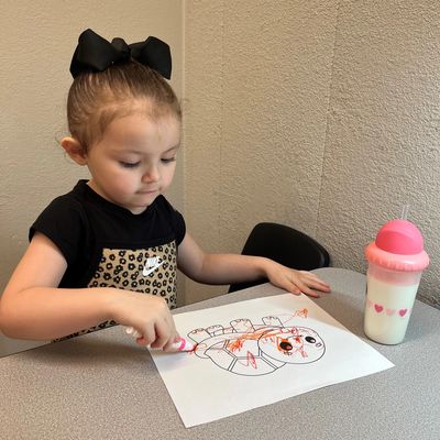 Child working on fine motor skills while coloring during occupational therapy