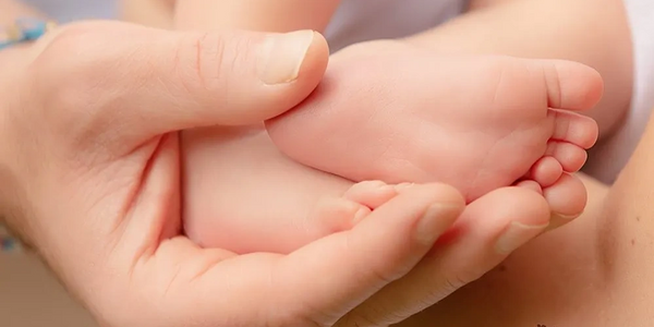 baby feet in dads hands - newborn baby photography 
