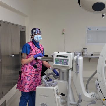 Medical professional operating imaging equipment in a hospital room.