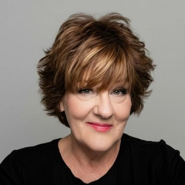 Smiling middle-aged woman with short, layered brown hair and light makeup.