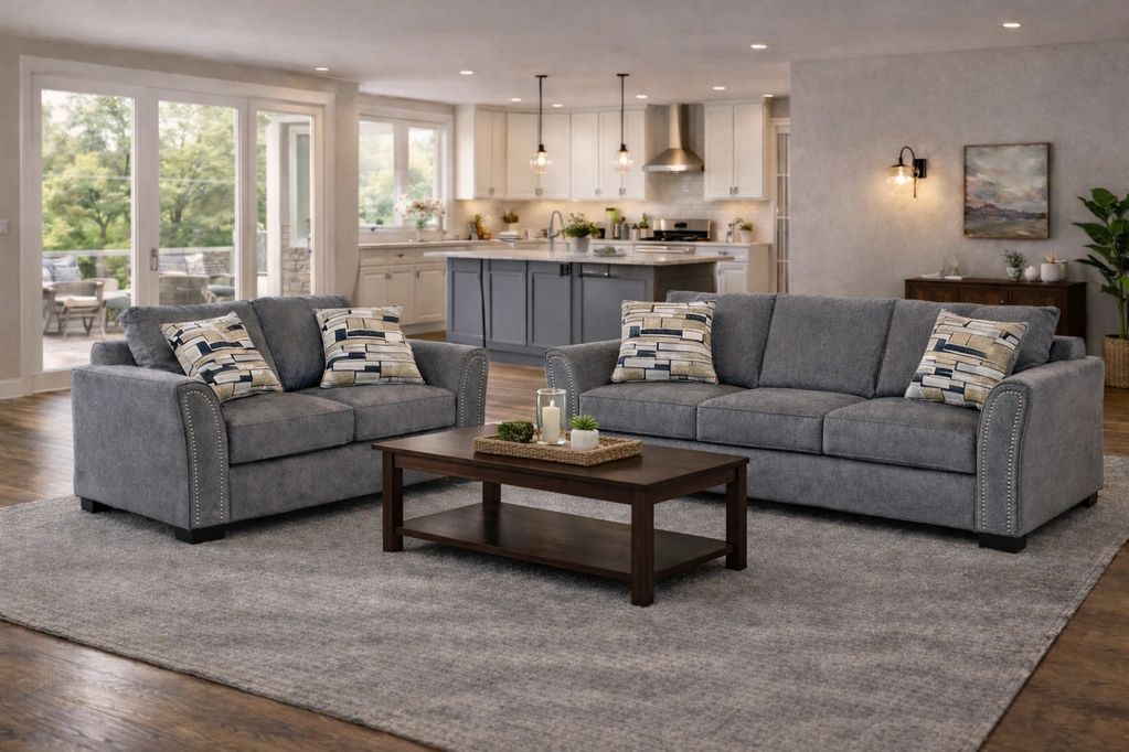 Cozy living room with grey sofas and a wooden coffee table in front of a modern kitchen.