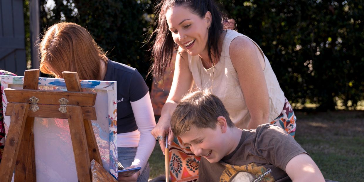 Holistic Integrated Creative Arts Therapist Jessica working with teenagers outdoors on art project
