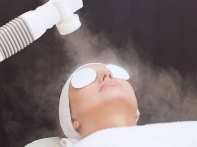Person receiving a facial steam treatment with eye protection.