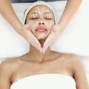 Woman receiving a facial treatment with cream applied.