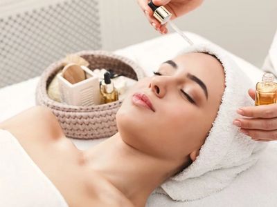 A woman receiving a relaxing facial serum treatment at a spa.