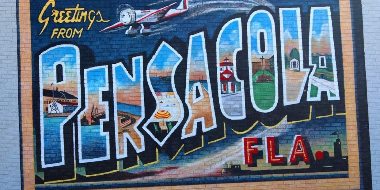 Colorful mural saying "Greetings from Pensacola, FLA" with local landmarks.