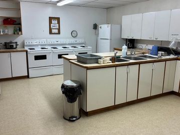 A clean, simple kitchen with white appliances and cabinets.