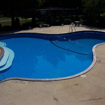 Empty outdoor swimming pool with clean blue water.