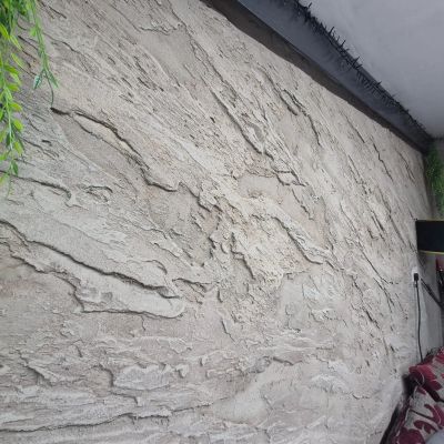 Textured beige wall with rough stucco finish.