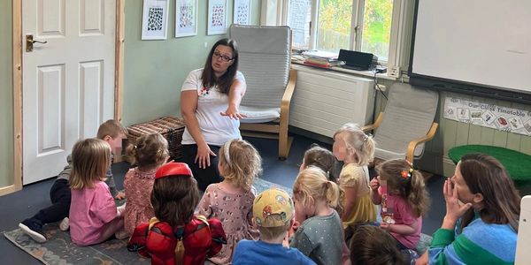 Teacher showing a group of preschoolers the sign for short.