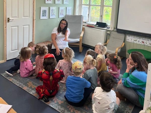 Teacher engaging young children in a classroom storytime session.