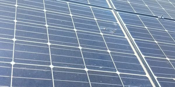 Close-up of solar panels with visible damage on some cells.