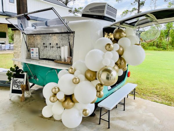 Barley-Yard Mobile Taps Camper decorated in white and gold balloons. 