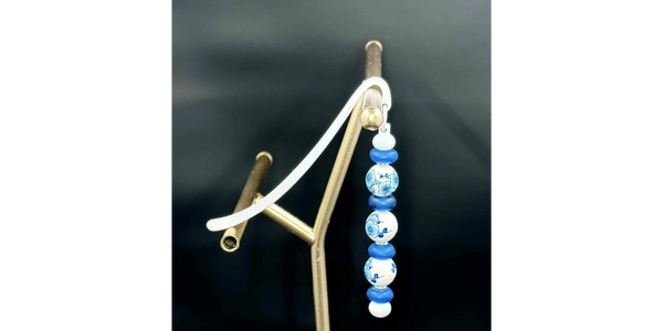 Elegant beaded bookmark featuring a silver clip and intricate blue and white floral design.