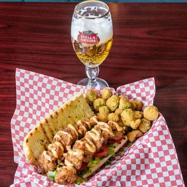 Shrimp po boy served with draft beer.  Full bar available