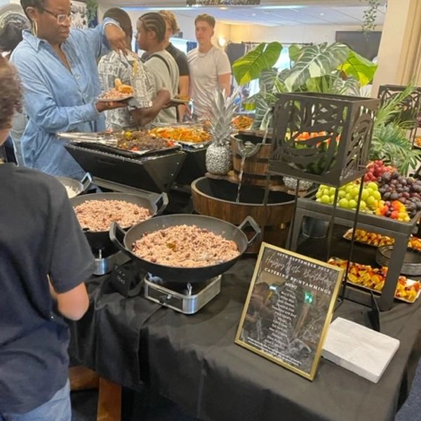 People serving themselves food buffet style.