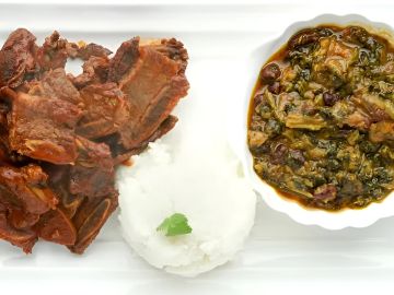 A plate with cooked meat, white rice, and vegetable stew.