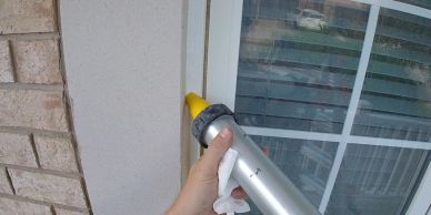 applying caulking to window