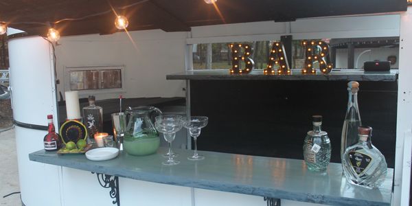 Mobile Bar features Wine Fridge, Two Ice Wells, Accessories, Bar Stools and Photo Backdrop