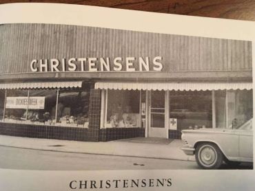 Vintage black-and-white photo of Christensen's store with a classic car.