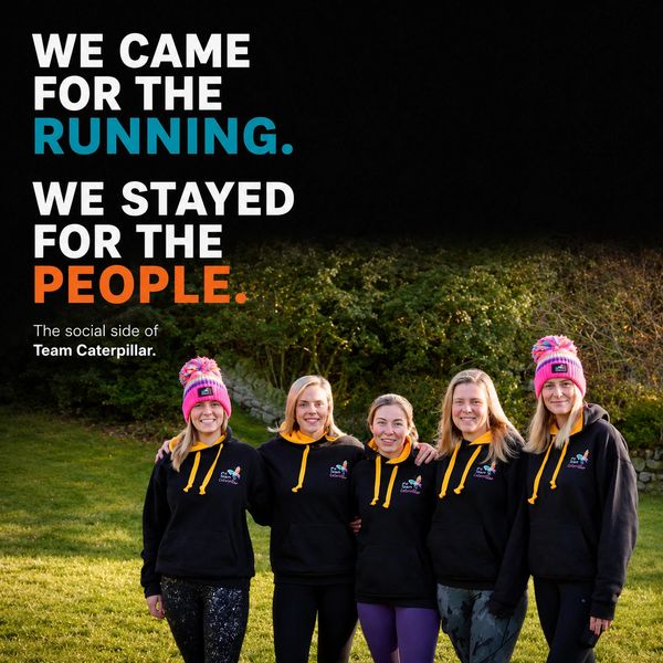 Five women in matching hoodies and bright pink hats promoting Team Caterpillar's social spirit.
