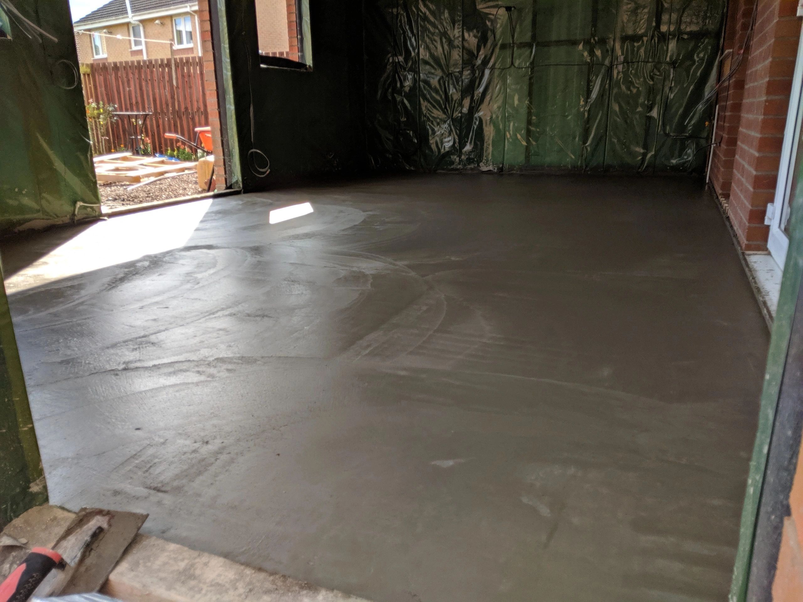 Newly laid smooth concrete floor inside a building under construction.