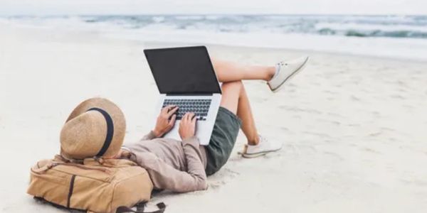 Person working at the beach on their laptop