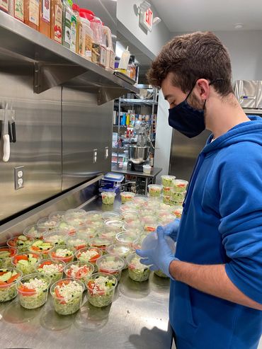 Mission Belly Full meals being prepared for donation by volunteer.