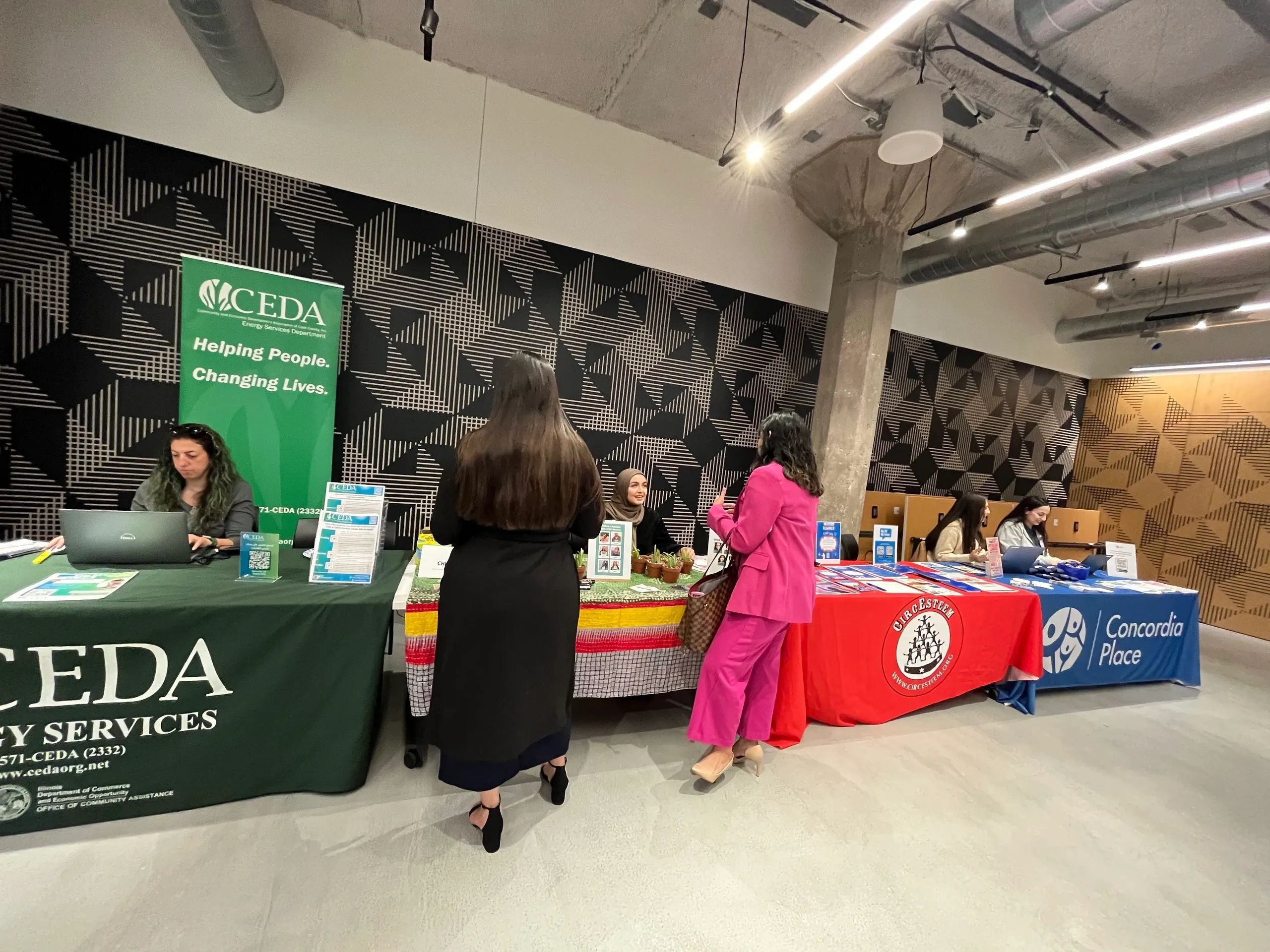 Two women approached a table to obtain resources from the organization. 