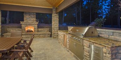 Outdoor dining area fireplace outdoor kitchen paver stone concrete countertops