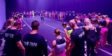 Dancers in a circle holding hands on stage.