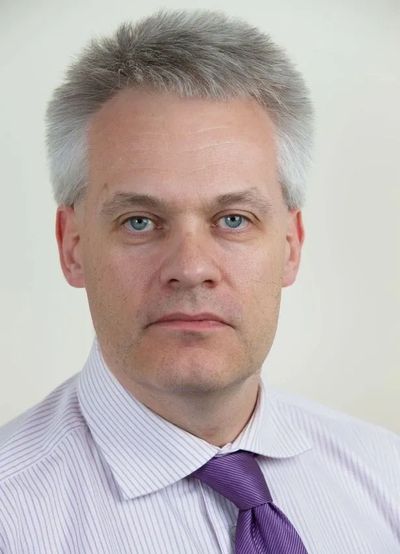 Professional middle-aged man in a striped shirt and purple tie.