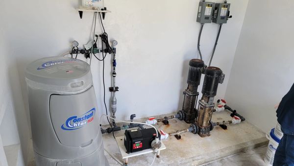 Chlorine dosing system with pumps and control gauges in a utility room.